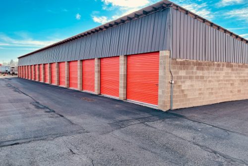 a storage building with red doors and a sky background